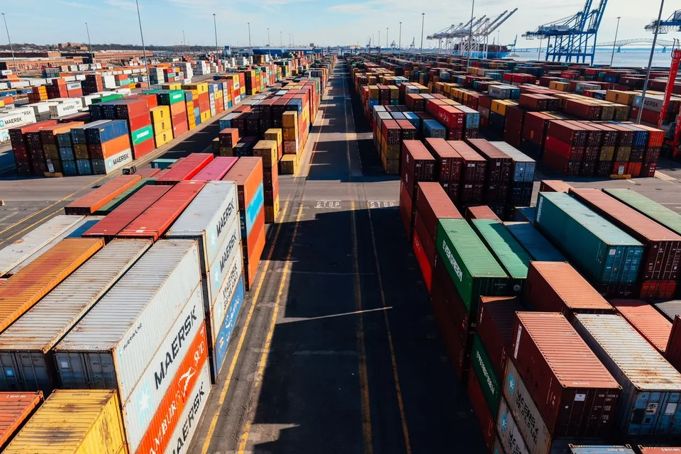 Terminal logística con contenedores organizados, reflejando seguridad, puntualidad, eficiencia y compromiso operativo