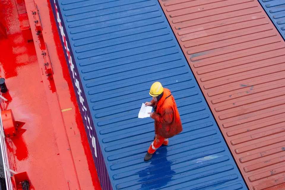 Personal supervisando contenedores y documentación en operación marítima de comercio exterior